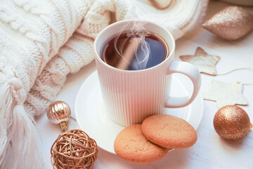     Winter, Christmas, New Year decorations composition, concept, background. White Mug, cup of tea, coffee, steam, cookies, spruce branches, knitted plaid. Christmas mood morning. Christmas  card.