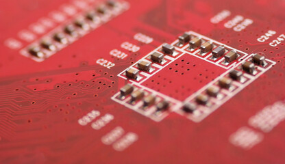 Czerwona płytka elektroniczna z elementami.