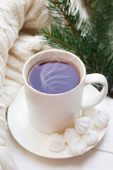 Fototapeta na wymiar Winter, Christmas, New Year decorations composition, concept, background. White Mug, cup of tea, coffee, steam, meringue, knitted plaid. Christmas lights. Christmas mood morning. Christmas card.
