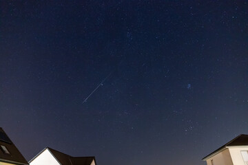 Starry sky over a housing settlement with meteorites (Perseids in August)