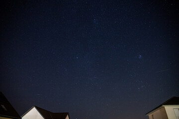 Starry sky over a housing settlement with meteorites (Perseids in August)