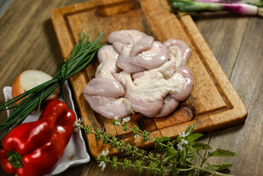 Cow bowels presented on a wooden board with ingredients, ready to grill