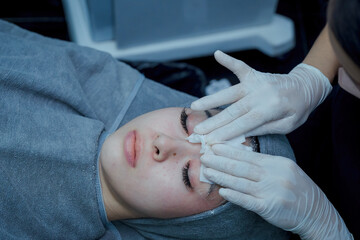 The female dermatologist do face massaged to beautiful girl cosmetology cabinet or beauty clinic. Concept of face cleanser, skin and health care