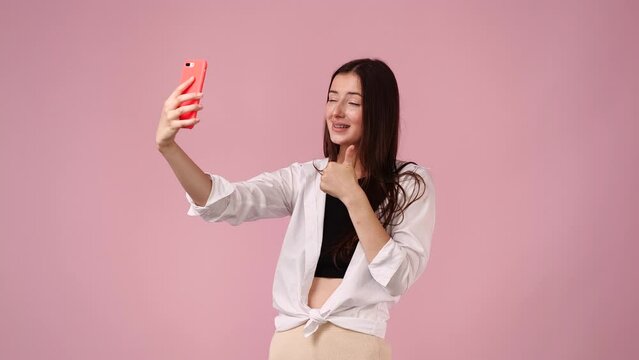 4k video of female woman taking selfie over pink background.