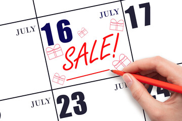 Hand writing text SALE and drawing gift boxes on calendar date July 16. Shopping Reminder