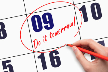 9th day of the month. Hand writing text DO IT TOMORROW and circling the calendar date. Save the...
