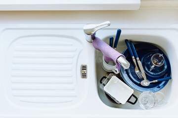 Kitchen sink filled with dirty dishes. view from above