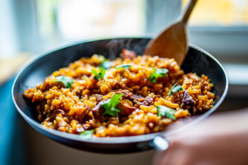 cooking tasty rice, meat and vegetable in pan on kitchen