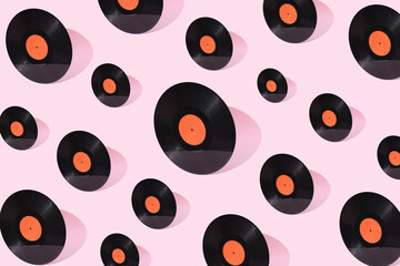 Vinyl records on a pastel pink background. Creative black circles pattern of different sizes. Retro...