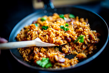 cooking tasty rice, meat and vegetable in pan on kitchen