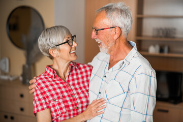 Portrait of happy senior couple at home. Seniors embracing.