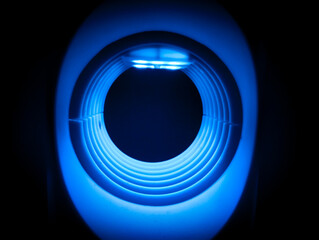 The circular tunnel has a blue neon glow in the dark.