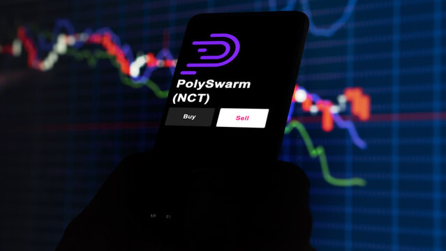 September 13th 2022, London UK. An investor's analyzing the PolySwarm (NCT) coin on screen. A phone shows the ETF's prices to invest