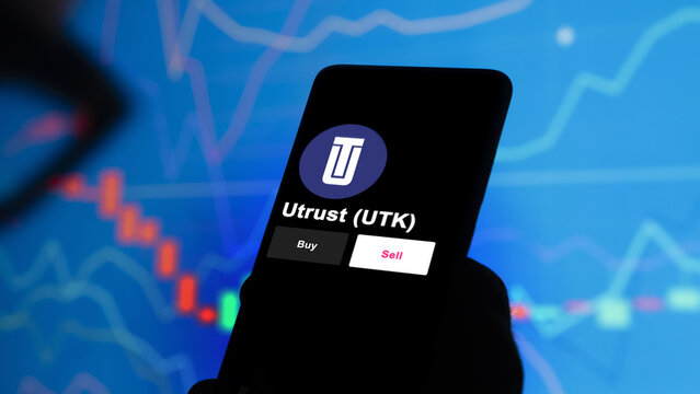 September 13th 2022, London UK. An investor's analyzing the Utrust (UTK) coin on screen. A phone shows the ETF's prices to invest