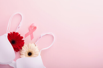 Breast Cancer Awareness Ribbon. White and red bra, gerberas with pink ribbon tape lying on female bra on backgrounds. Breast cancer awareness and October Pink day, world cancer day. Top view. Mock up