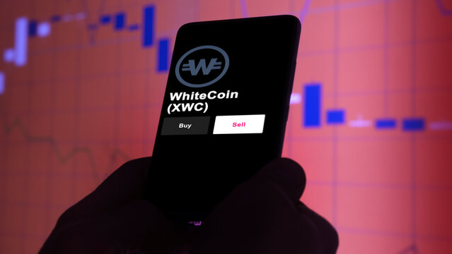 September 13th 2022, London UK. An investor's analyzing the WhiteCoin (XWC) coin on screen. A phone shows the ETF's prices to invest