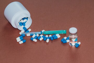 Closeup of illegal doping injectable drug and capsules on a table - cheating drug in sports