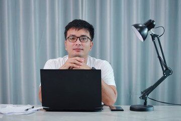 technology, remote job and lifestyle concept - happy asian man  man in glasses with laptop computer working at home office or online shopping, home work, freelance, online learning, studying.