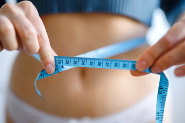 Measuring. Close-up slim female body
