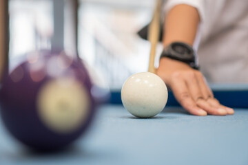 Snooker Hand playing with cue aiming on billiard ball at table