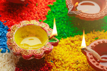 Oil lamps lit on colorful rangoli or rice during diwali celebration