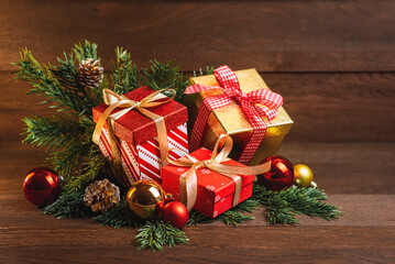 Fototapeta na wymiar Merry Christmas and Happy New Year. Boxes with gifts, Christmas toys and fir branches on a wooden background