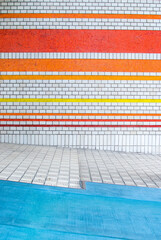 オレンジ色のストライプのグラデーション模様の壁と水色の地面