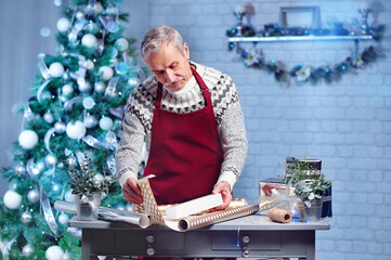 Senior man working in his Christmas gift wrapping workshop