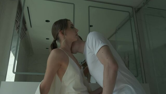 Young man kissing a girl on the neck in the bathroom