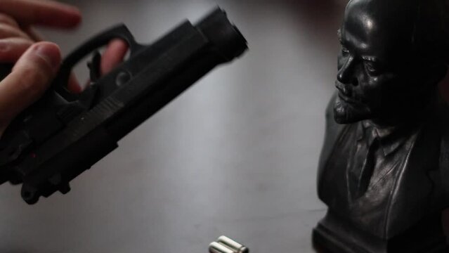 Loading Gun with Lenin Trinket. Russian Man Goes to War