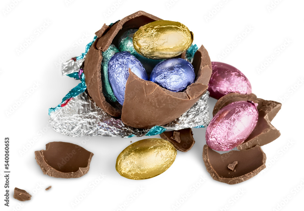 Wall mural broken chocolate easter egg wrapped in pink foil with colorful candies on white background