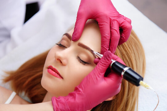 Closeup picture of a woman getting eyebrows permanent makeup procedure