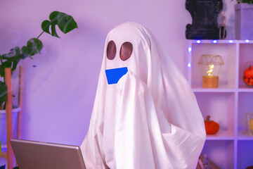 ghost of Halloween uses laptop surf the Internet, browse online stores, markets. A ghost makes an order from computer for Halloween. Ghost pays for online purchase by credit, bank card. Neon light.