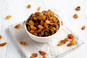 Organic Dried Raisins in a White Bowl, side view. Close-up.