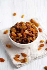 Organic Dried Raisins in a White Bowl, side view.