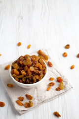 Organic Dried Raisins in a White Bowl, side view. Space for text.