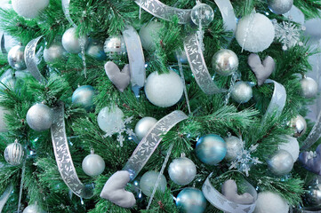 Closeup picture of a decorated in silver colours pine tree