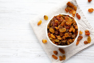 Organic Dried Raisins in a White Bowl, top view. Overhead, from above, flat lay. Space for text.