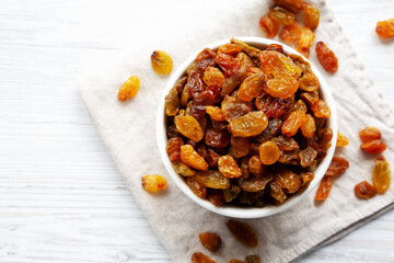 Organic Dried Raisins in a White Bowl, top view. Overhead, from above, flat lay. Copy space.