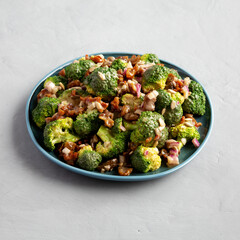Homemade Broccoli Bacon Salad on a Plate on a gray background, side view.