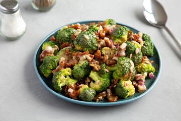 Homemade Broccoli Bacon Salad on a Plate on a gray background, side view.