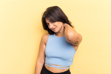 Obraz premium Young Indian woman isolated on yellow background suffering neck pain due to sedentary lifestyle.