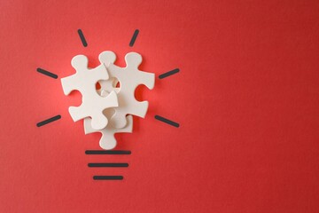 Lightbulb from puzzles on red background with copy space. Inspiration, creative idea concept.
