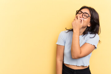 Young Indian woman isolated on yellow background laughing happy, carefree, natural emotion.