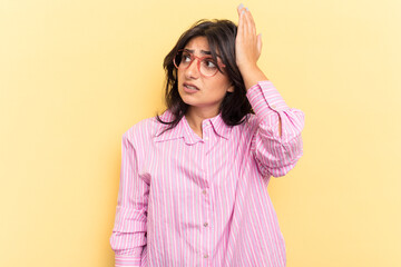 Young Indian woman isolated on yellow background being shocked, she has remembered important...