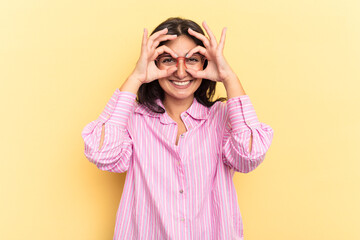 Young Indian woman isolated on yellow background excited keeping ok gesture on eye.