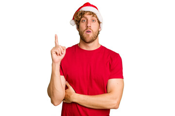 Young caucasian man wearing a Christmas Santa hat isolated on white background having some great idea, concept of creativity.