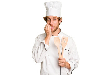 Young cook man isolated on white background biting fingernails, nervous and very anxious.