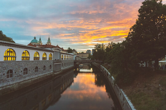 Beautiful sunset over Ljubljanica River with St Nicholas Church and Butcher&rsquo;s bringe at the background in Ljubljana, Slovenia. Picture made from Dragon Bridge.