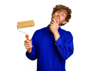 Young painter man holding a roll isolated on white background looking sideways with doubtful and skeptical expression.